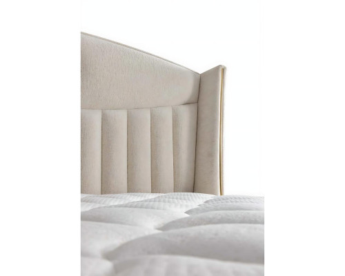 Κομψό κρεβάτι με μαξιλάρι από ανοιχτό μπεζ ύφασμα και ξύλο